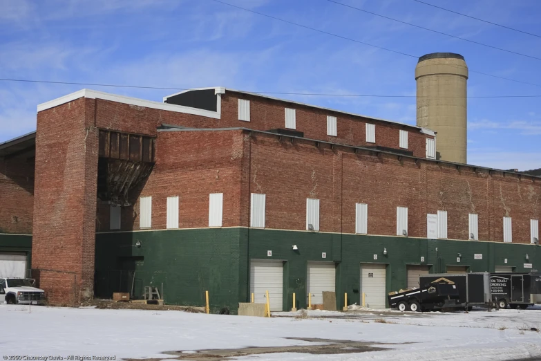 a large brick building with snow on the ground