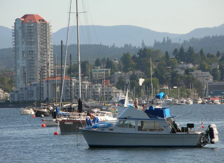 several boats in the water with buildings on the background