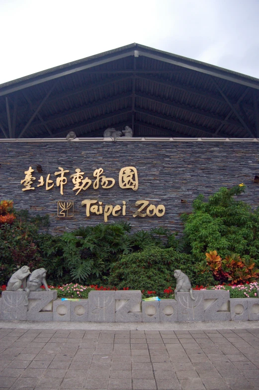 people walk near a sign that says the tokyo zoo