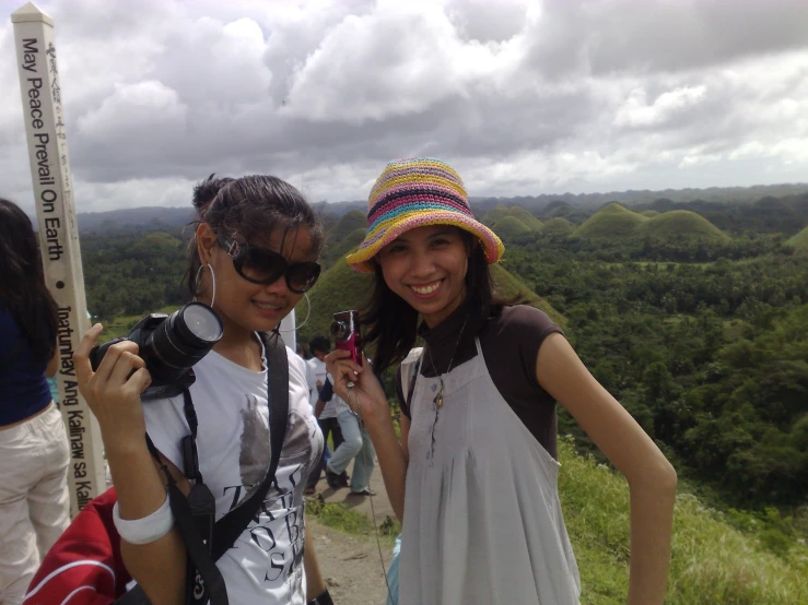 two women are smiling holding their camera equipment