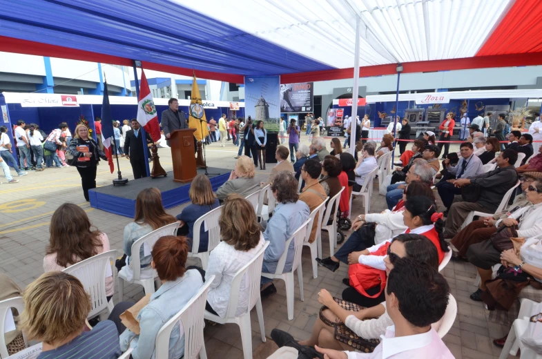 a man giving a speech to a crowd of people