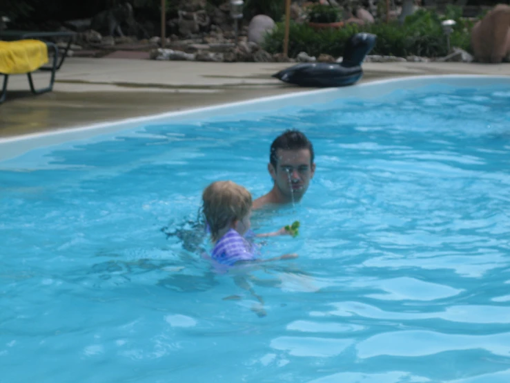 a man and a child playing in the pool