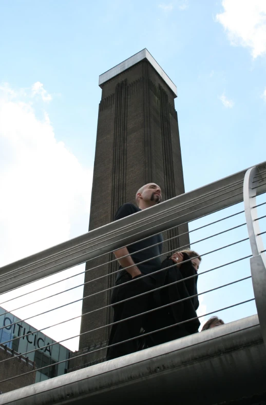 a man looking down from the top of a fence