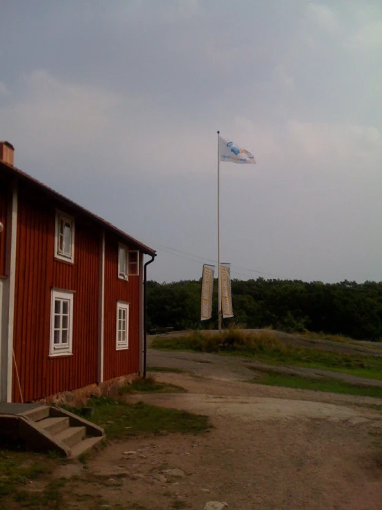 a red building with a flag on a pole