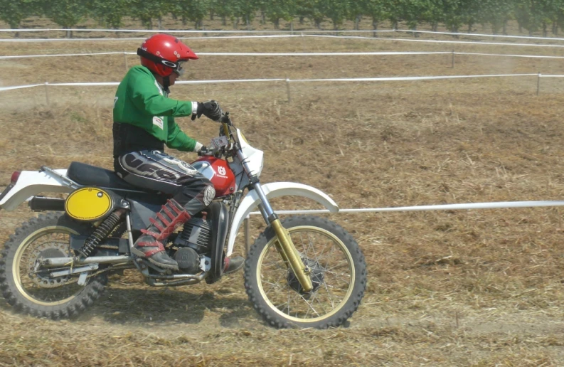a person wearing a helmet sitting on a dirt bike