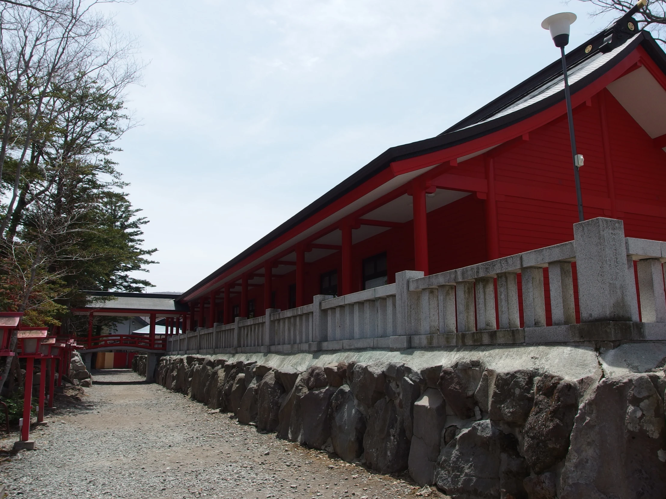 an empty street in front of a building with red and white walls