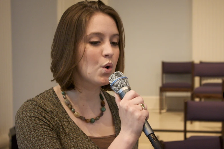 the woman is singing into her microphone in the church