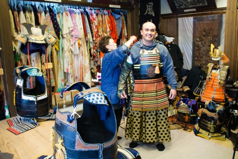 two men in the doorway of a shop selling colorful clothing