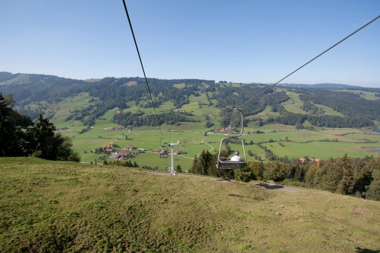 some electric wires hang above a grassy hill