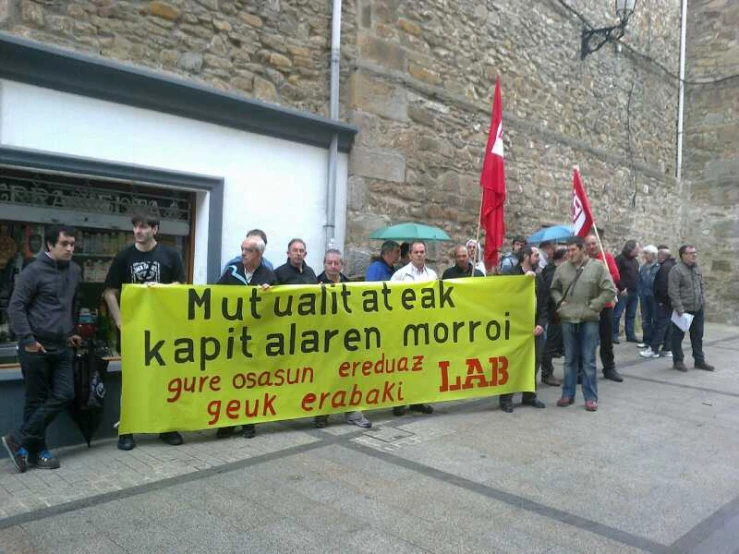 group of people holding signs with red flags on them