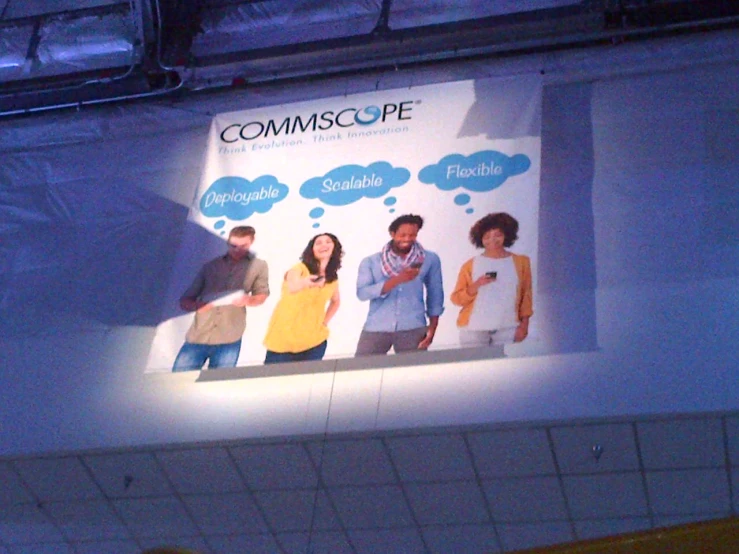 a billboard for commscople hanging from a ceiling