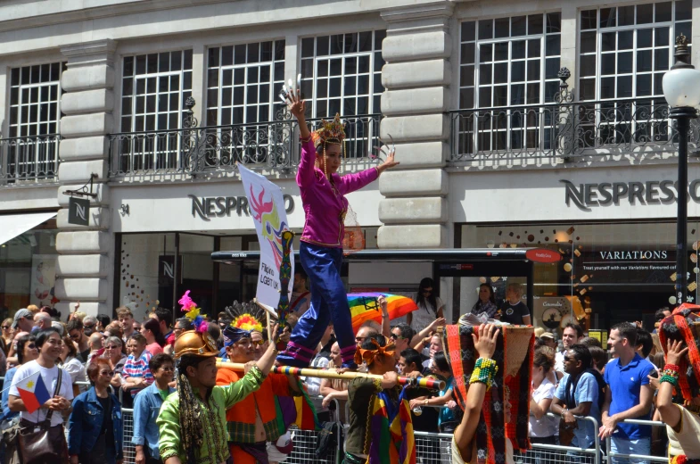 a woman dressed in clown clothes rides on a float