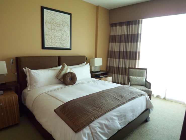 a large bedroom with yellow walls and white bedding