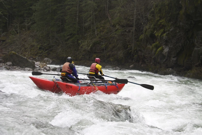 a couple in a red boat on some rapids