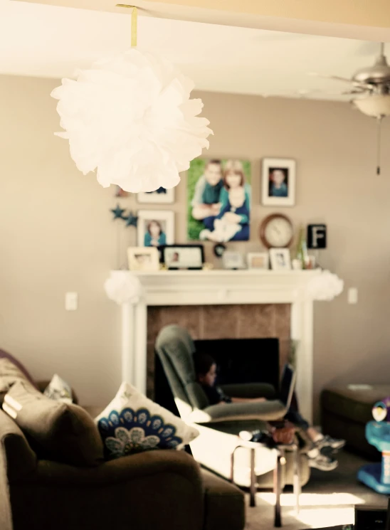 a fireplace with pictures on it and a light fixture in a living room