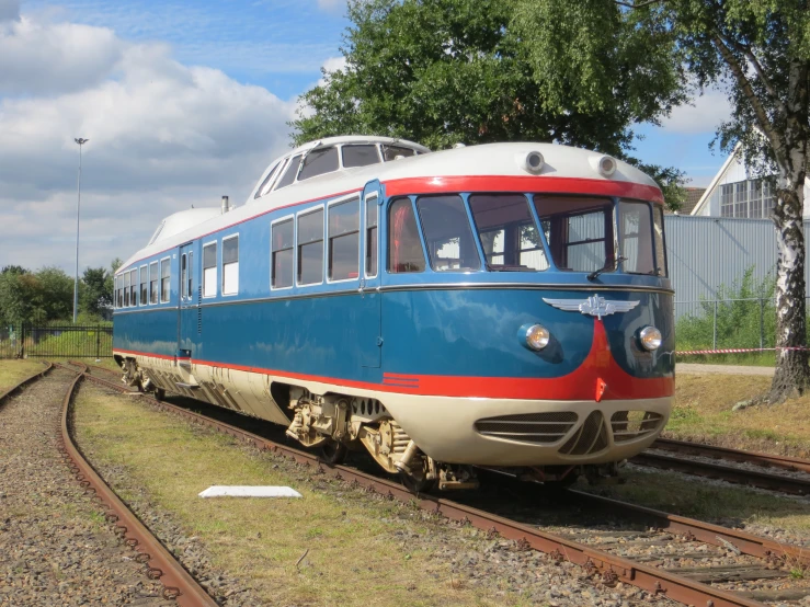 a very colorful train on the tracks near a field