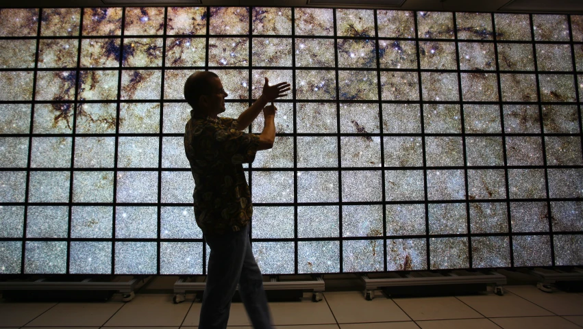 a man standing in front of a large wall painting