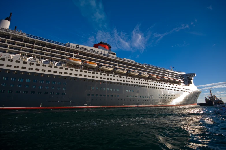 a large white cruise ship sailing next to a boat