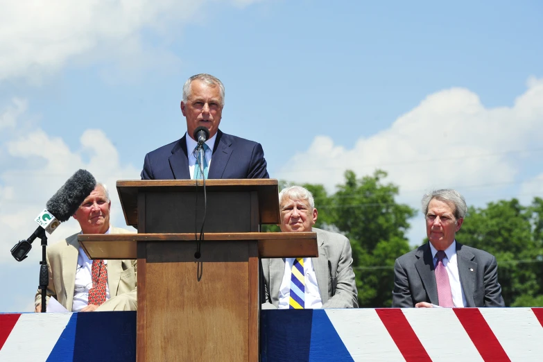 several people and a man speaking on a stage