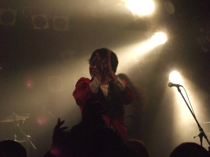 a woman standing on a stage holding her cell phone up to her face