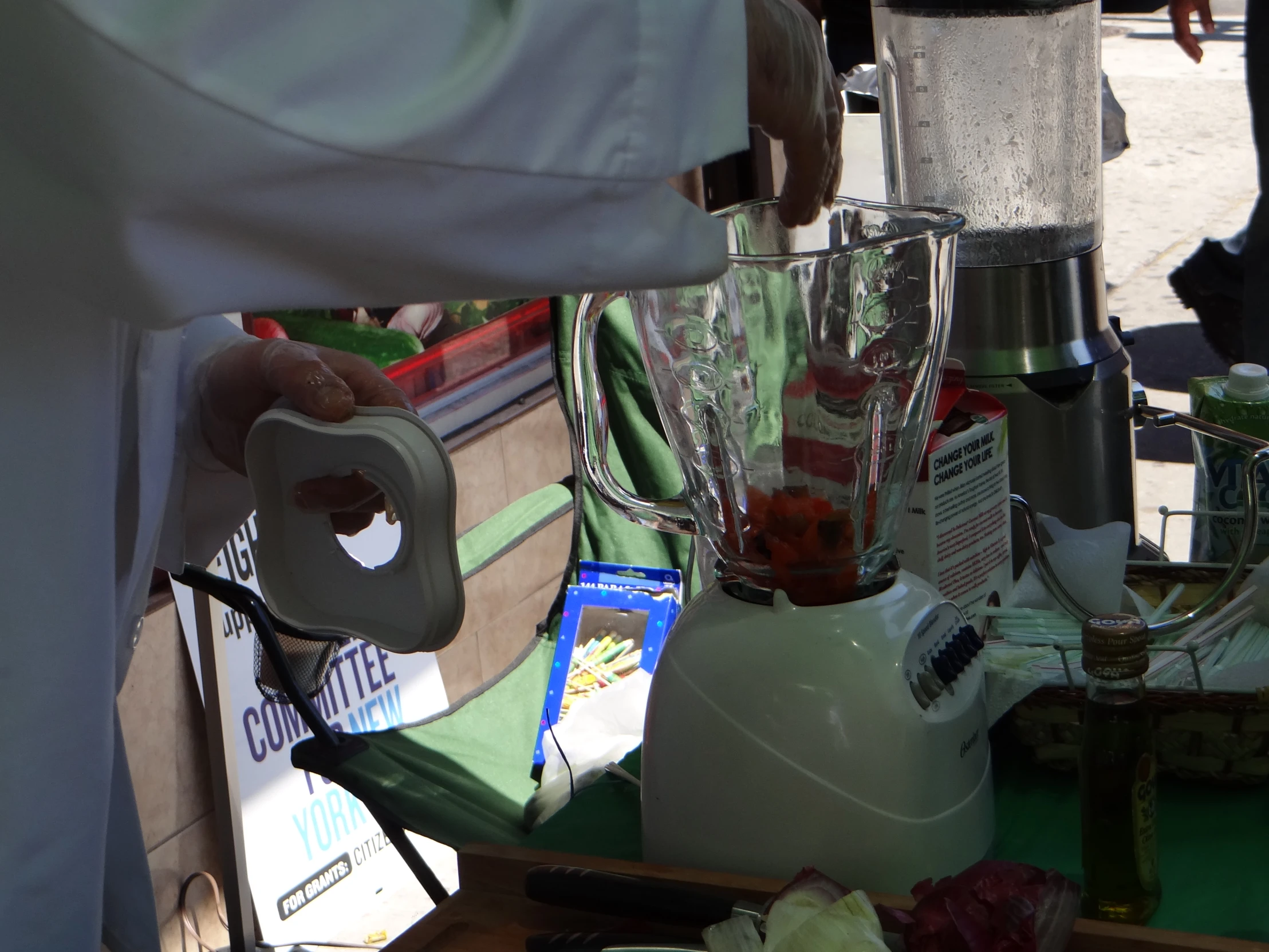 some green food stuff and a person holding a blender