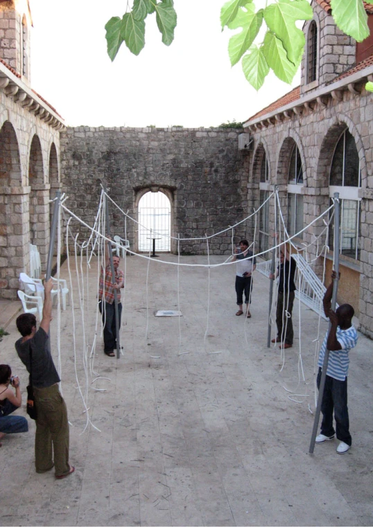 children play volleyball in an old brick walled building