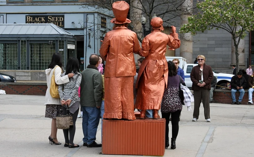 the two bronze statues stand in the middle of the road