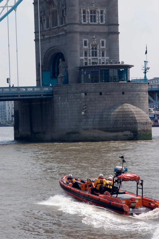 a tugboat rides on the water by a bridge