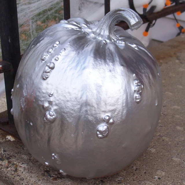 a metal pumpkin has some bubbles on it