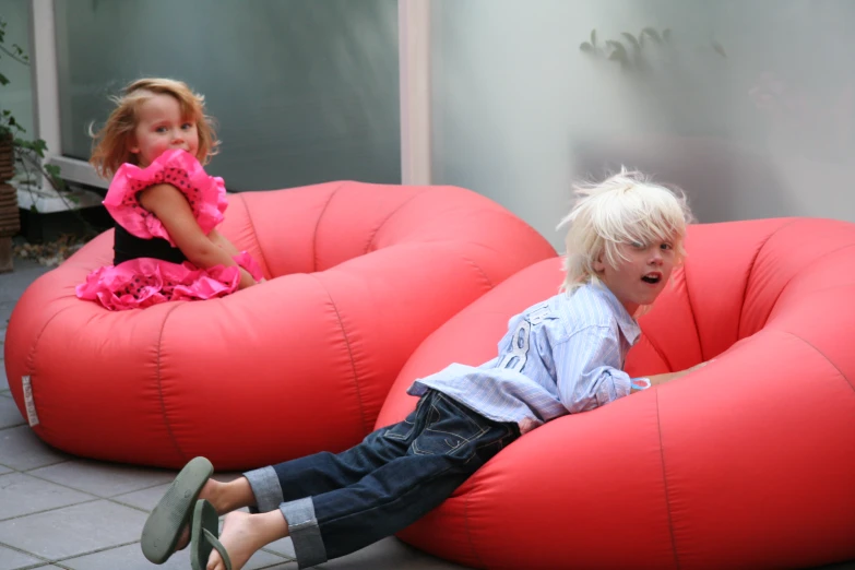 two small children play on a fake sofa