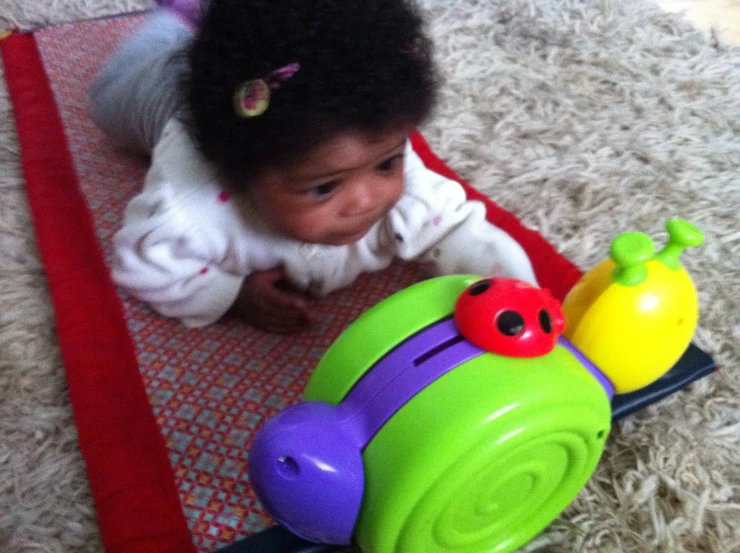 a baby is crawling along on the floor next to toy train