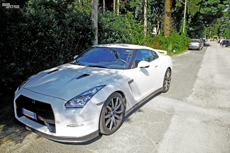 a white sports car is on the side of the road