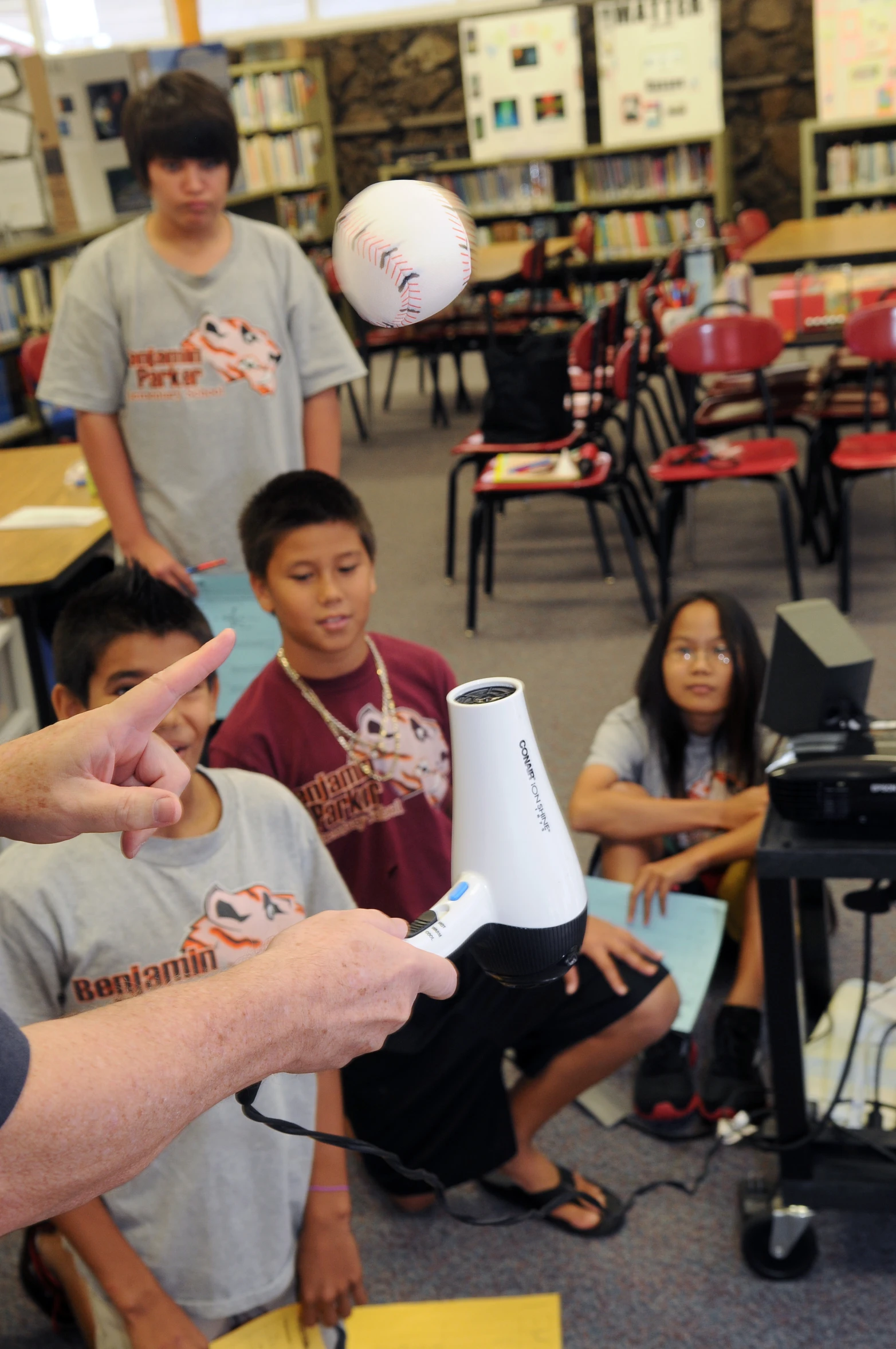 children and adults with remote controls in a classroom