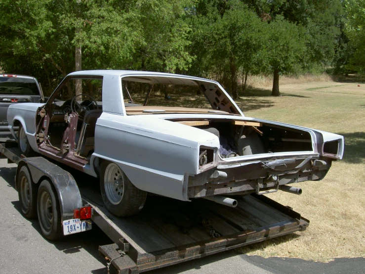 a car is on a flatbed trailer in a field