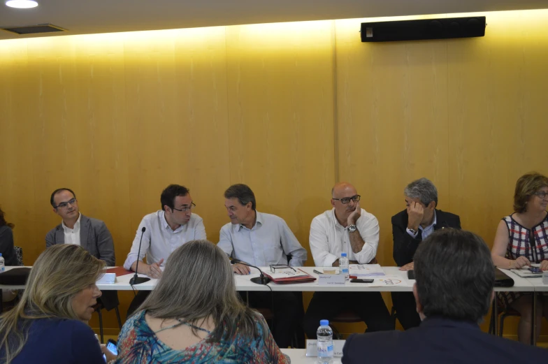 a group of people sitting at table with paperwork