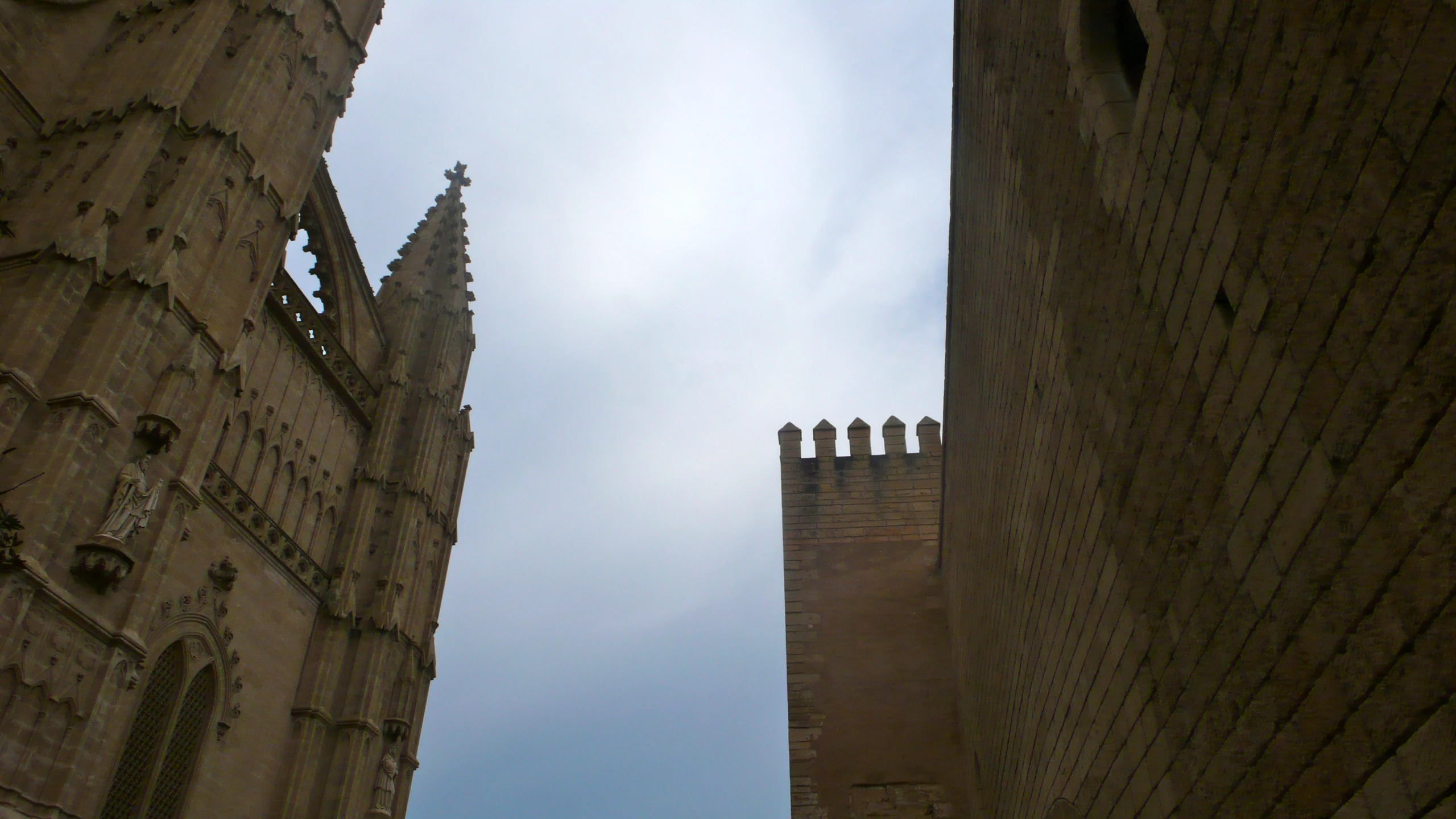 two tall buildings with statues on the top and a sky background