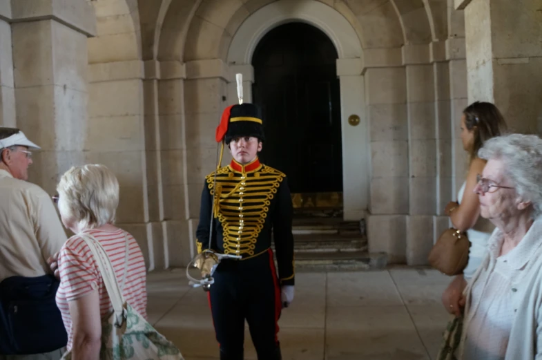 an old man in uniform standing next to some older women