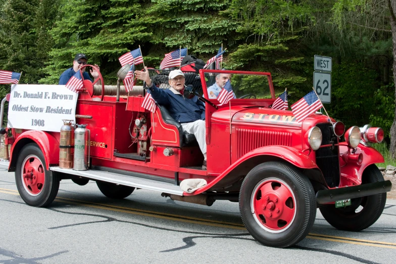 a man and several s riding in the back of a fire truck