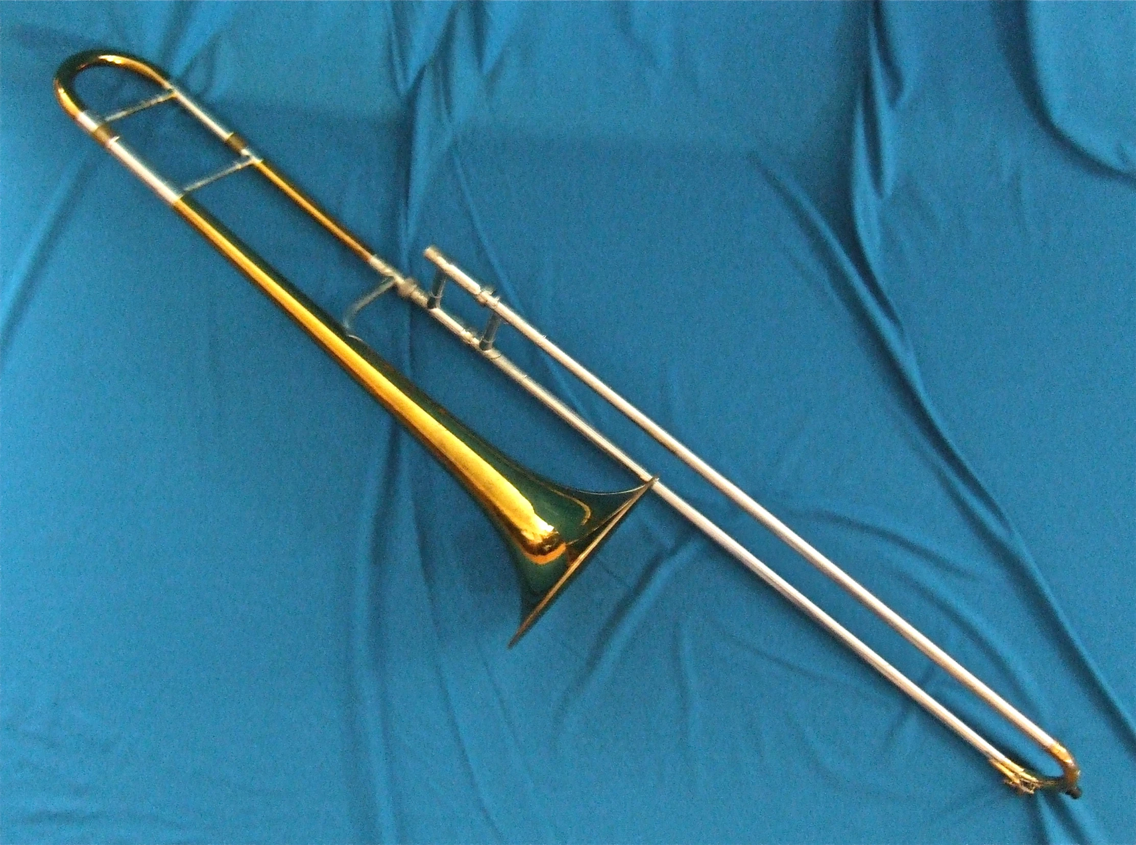 a ss trombone lies on a blue background