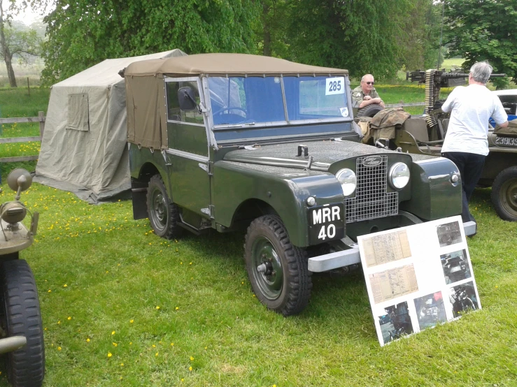 jeeps parked on grass with military equipment nearby