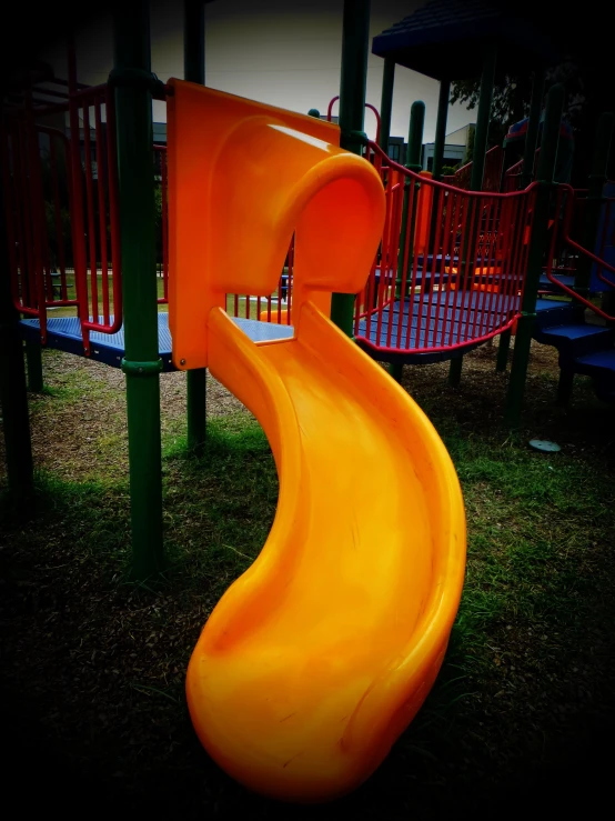 a playground is orange and yellow with a slide