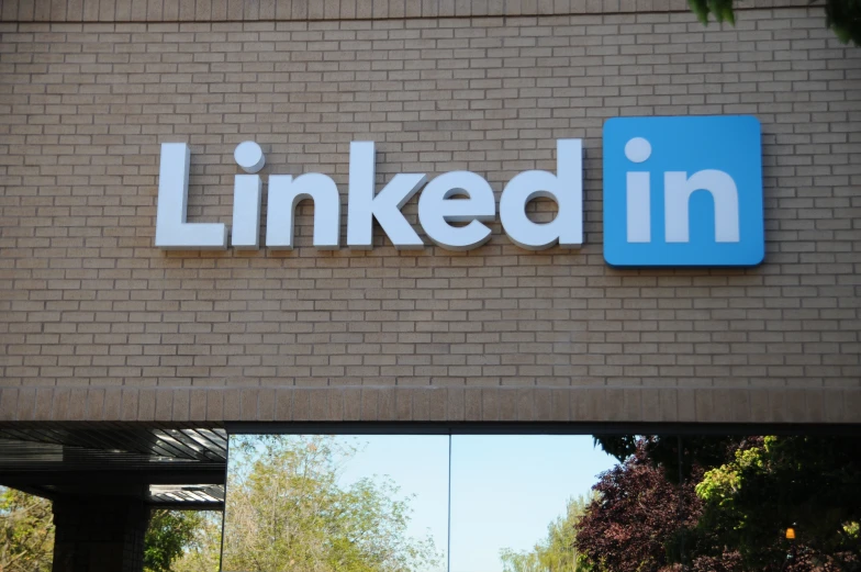 linked sign in front of brick wall with reflection on window