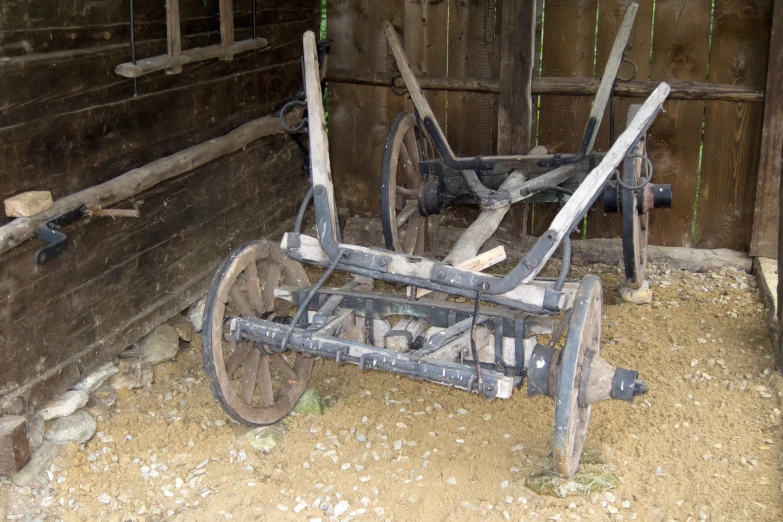 a rustic wooden farm equipment sits in the dirt