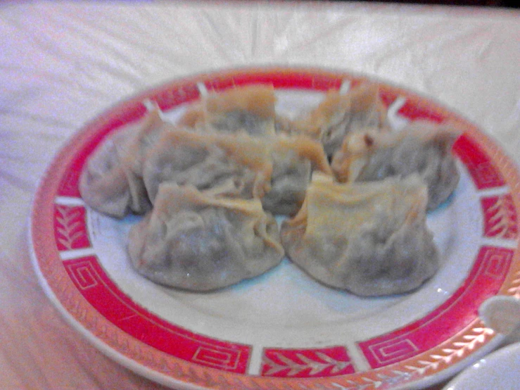 several dumplings sit on an orange and red plate