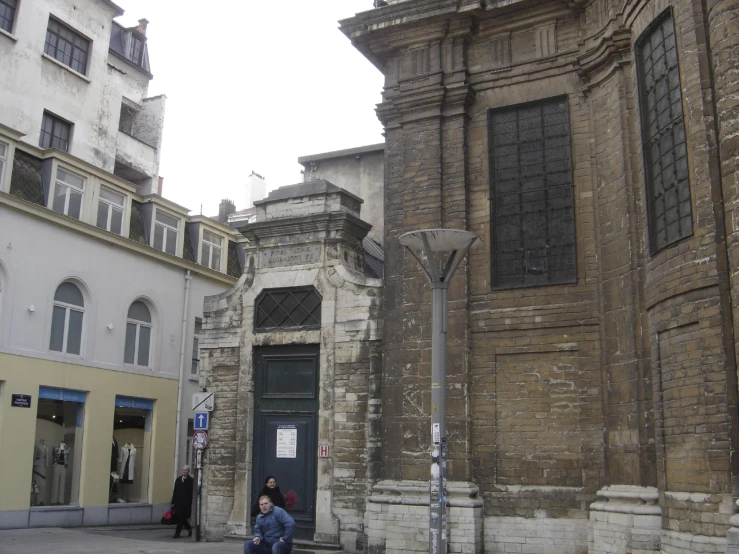 a street with people walking next to old buildings