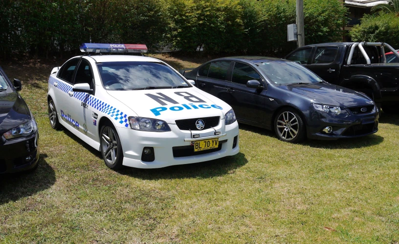 two police cars parked next to other police vehicles