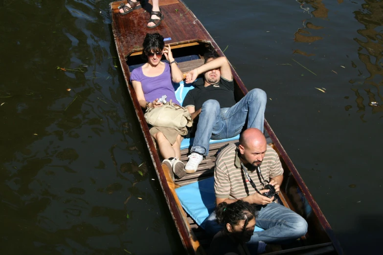 three people sitting in a small boat in the water