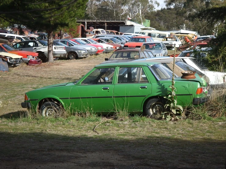 an old car in a junk yard full of other cars