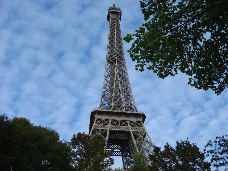 the eiffel tower against a cloudy blue sky