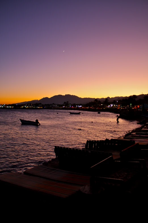 a few boats are sailing in the water near a pier